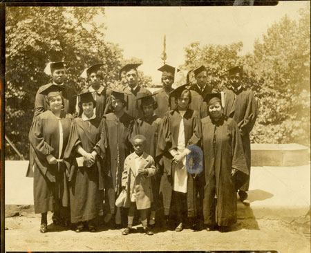 Black and white photo of young men and women in graduation gowns