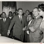 A black and white photo of Ted Berry with a group at the White House.  John F. Kennedy is standing near Berry.