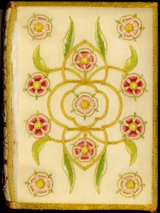 An embrodered book cover with red and pink flowers and vines