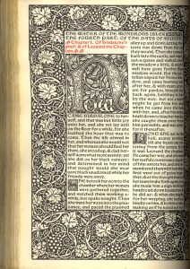 A page of text with the margins covered in a vine illustration.  The text is largely in black with the chapter title in red.