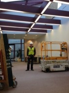 Construction working installing a temporary ceiling above the DAAP Library reading room.