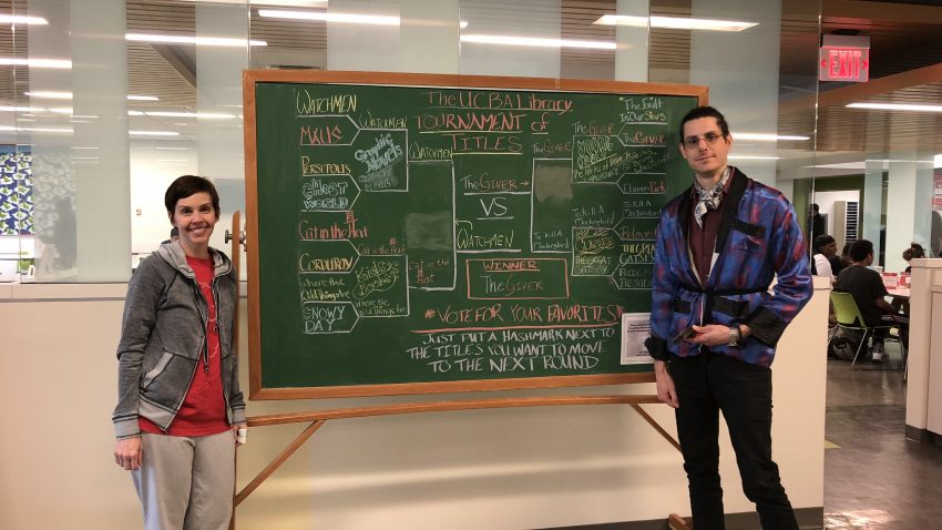 Lauren Wahman and Christian Boyles standing in front of the Book Bracket drawing