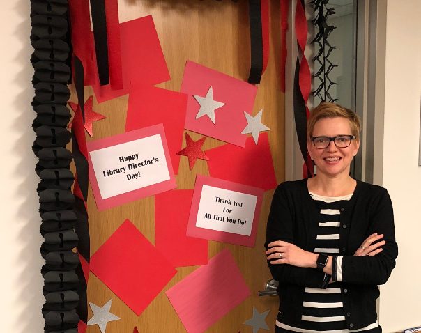 Heather Maloney in standing in front of her decorated office door.