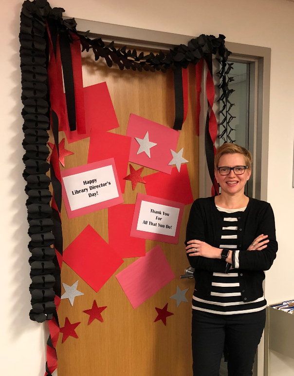 Heather Maloney in standing in front of her decorated office door.