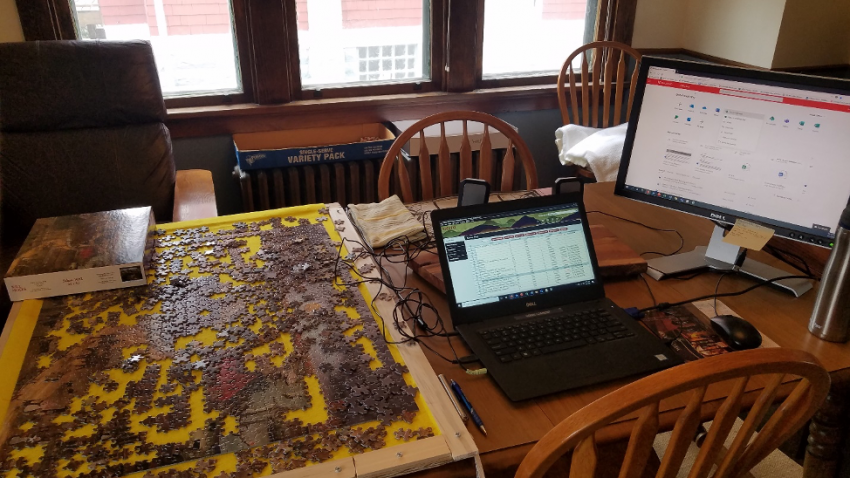 table with puzzle and computer workspace