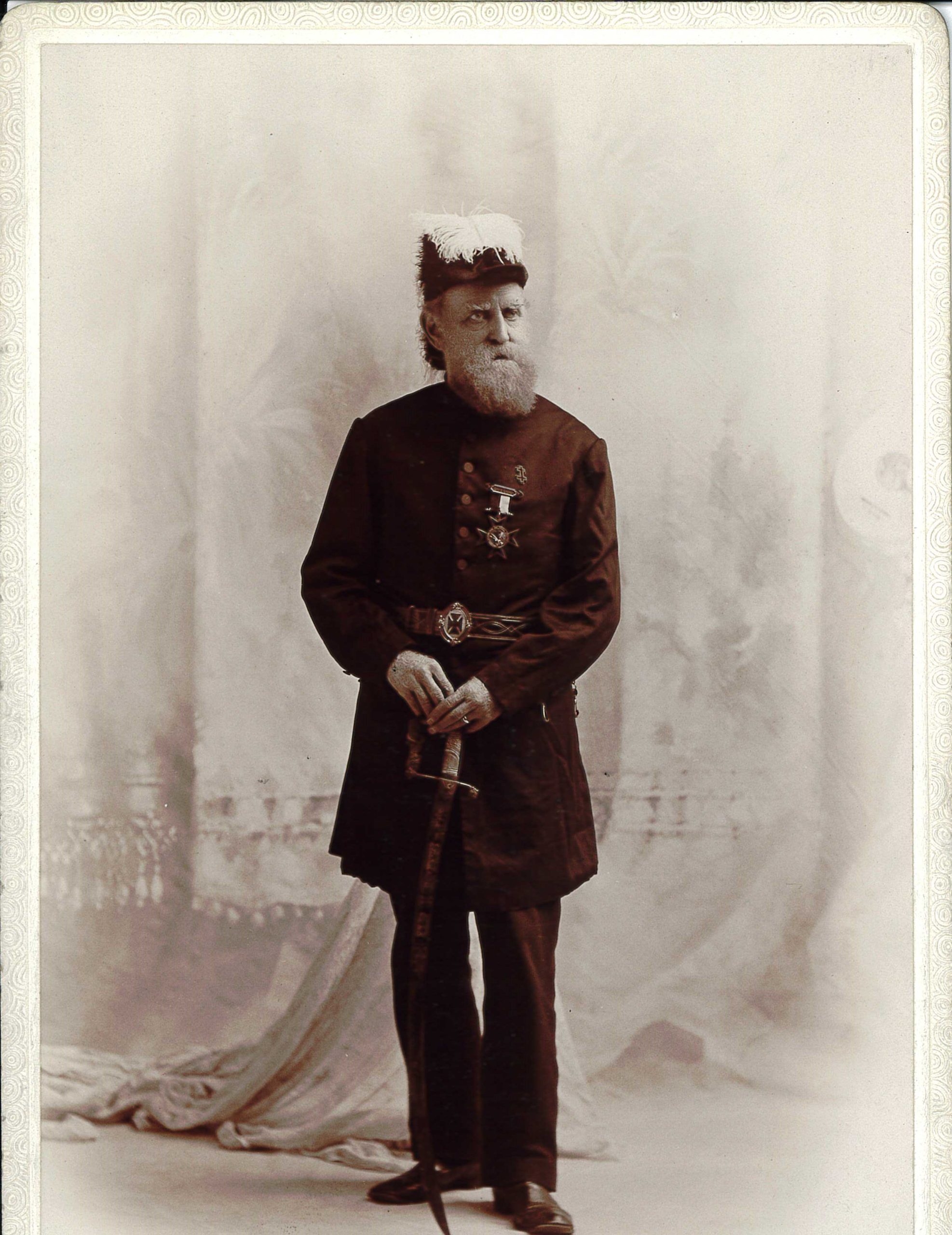 Photograph of John D. Caldwell standing in his masonic uniform and hat.