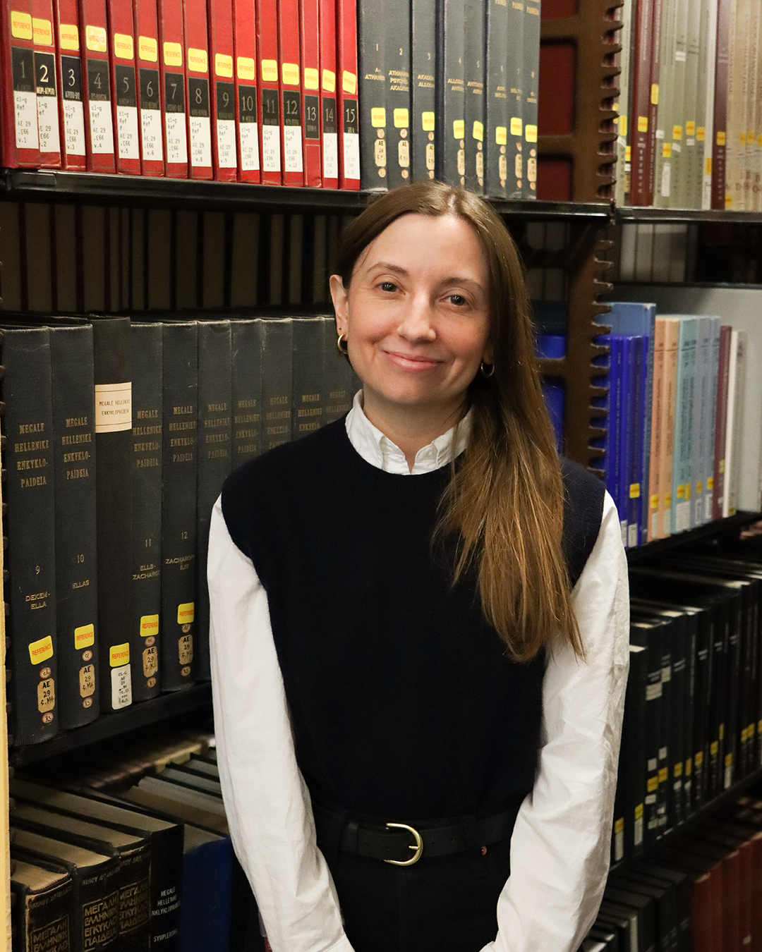 Corey Ferguson standing in front of the stacks in the Classics Library.