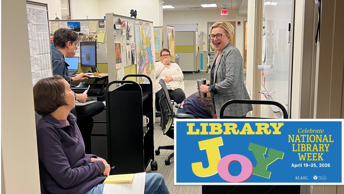 UCBA Library faculty and staff enjoying a laugh as they huddle around a white board.