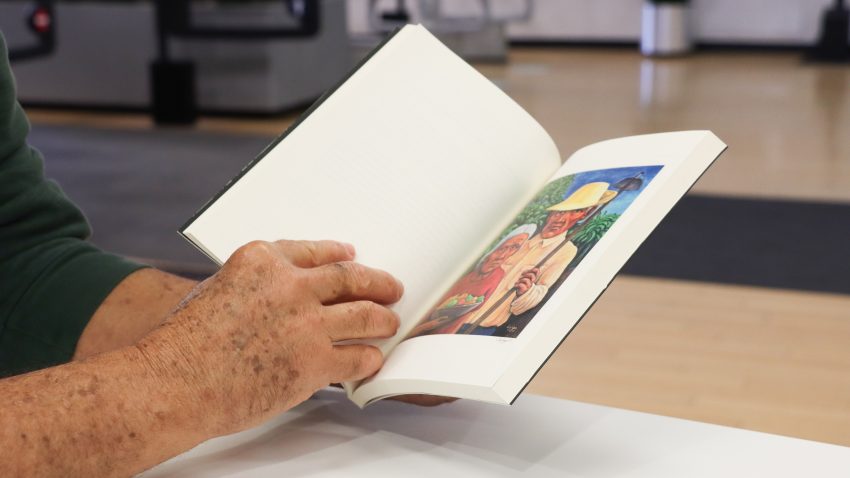 Open book with a Puerto Rican painting of jibaros.
