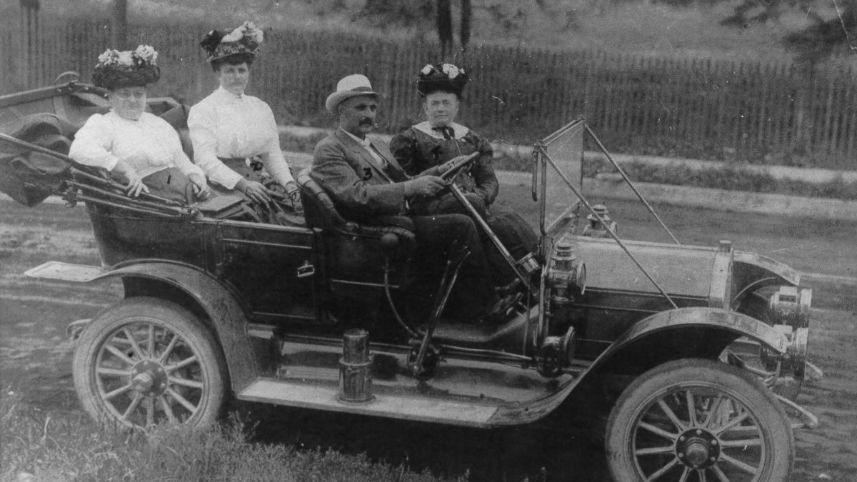 John Ruebel seated in the drivers seat of a Buick automobile with his wife Margaret next to him. In the back seat is Freda Kampf and Margaret Neusgable.