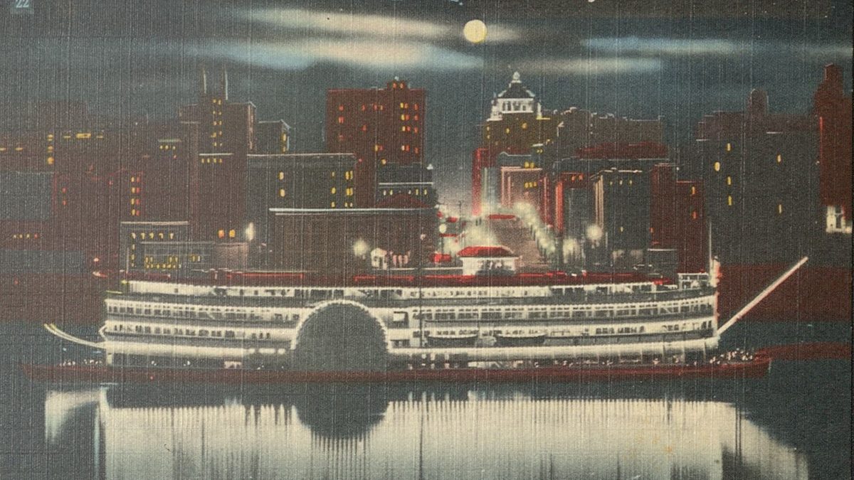 Postcard in color of "Island Queen" steamboat in the moonlight and being reflected off the river with the city skyline in the background. 