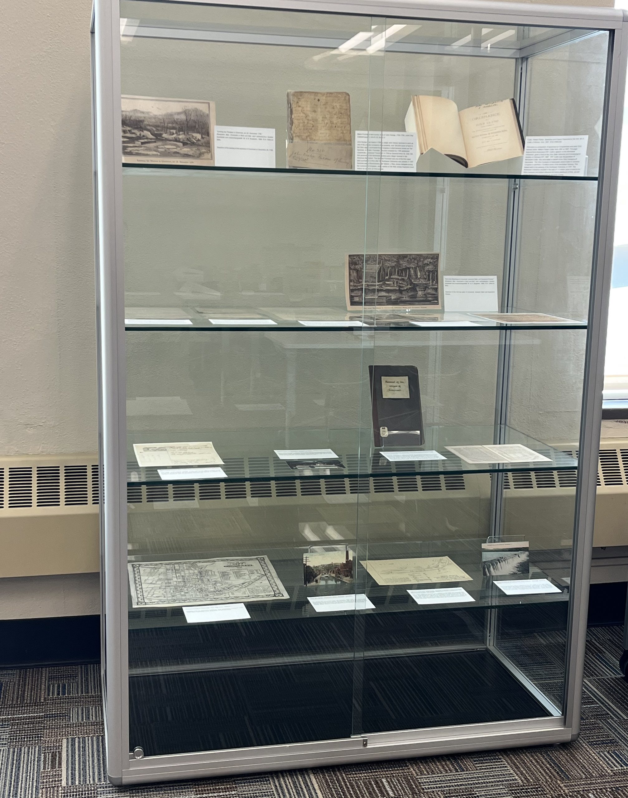 Photograph of items and labels inside of a large display case.