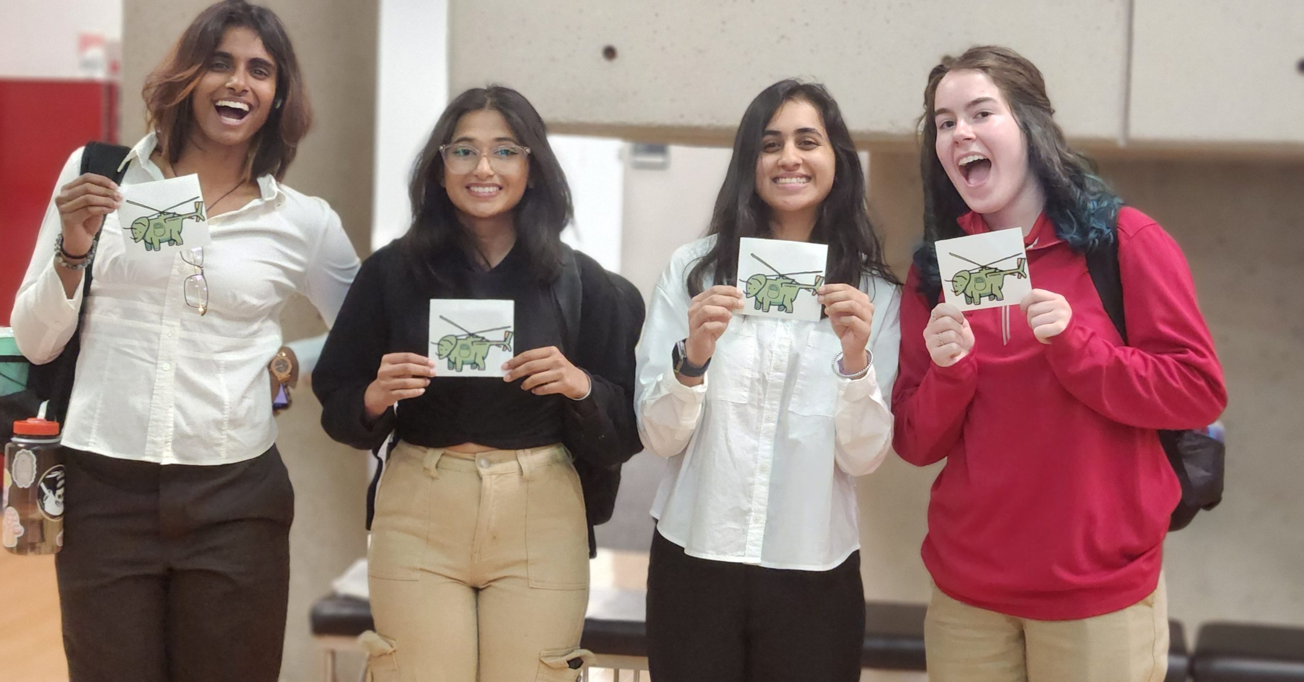 students holding triceracopter sticker
