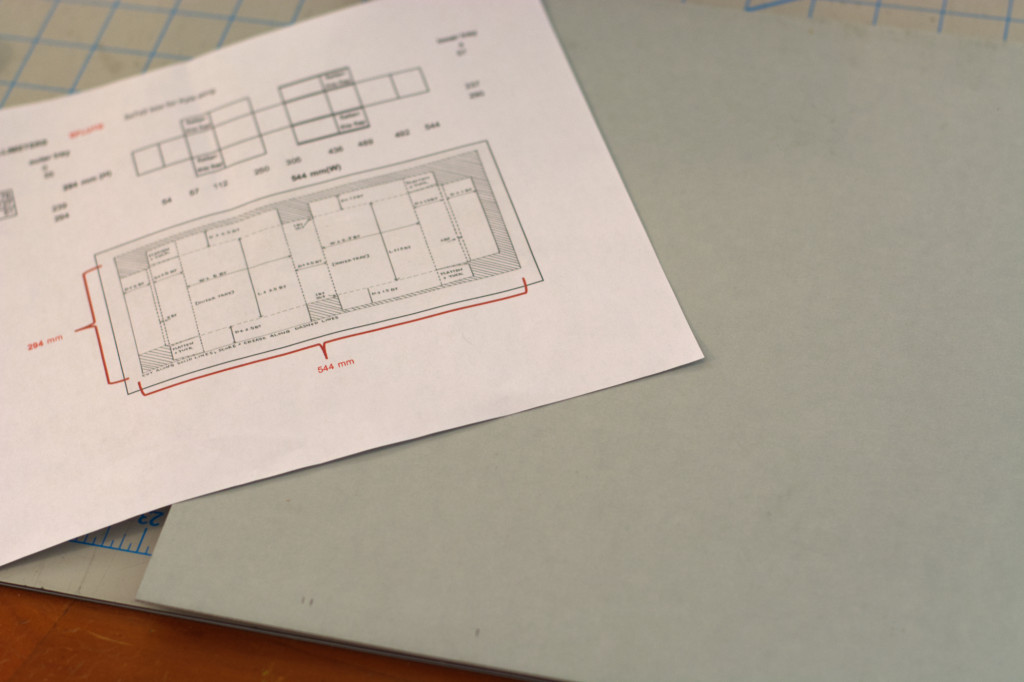 Excel spreadsheet over cut corrugated board on a cutting mat.