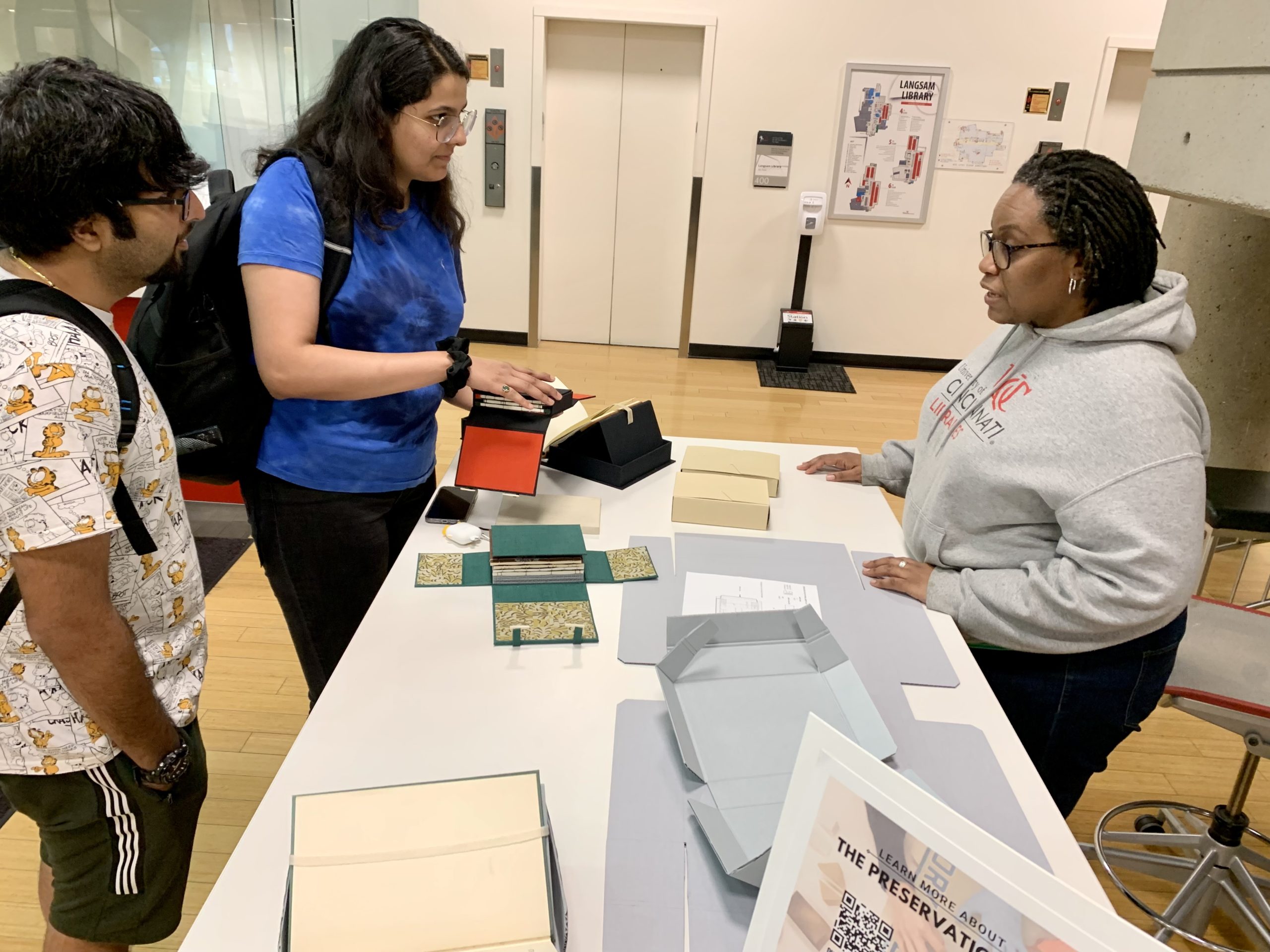 Students and Hyacinth with the 4-flap Japanese enclosure open.  The 4 flaps form a cross with the book laid in the center.