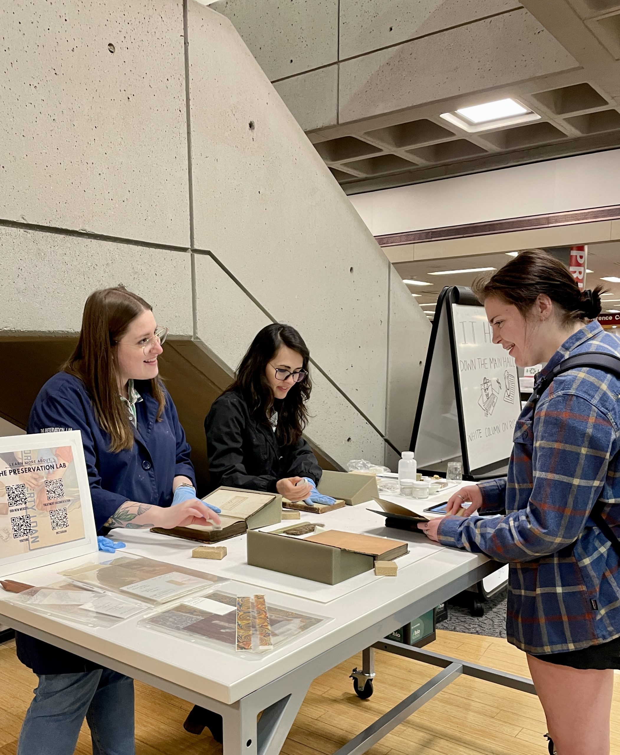 Student using a sponge to clean front of book.  Sponge moving from center of page towards edge.
