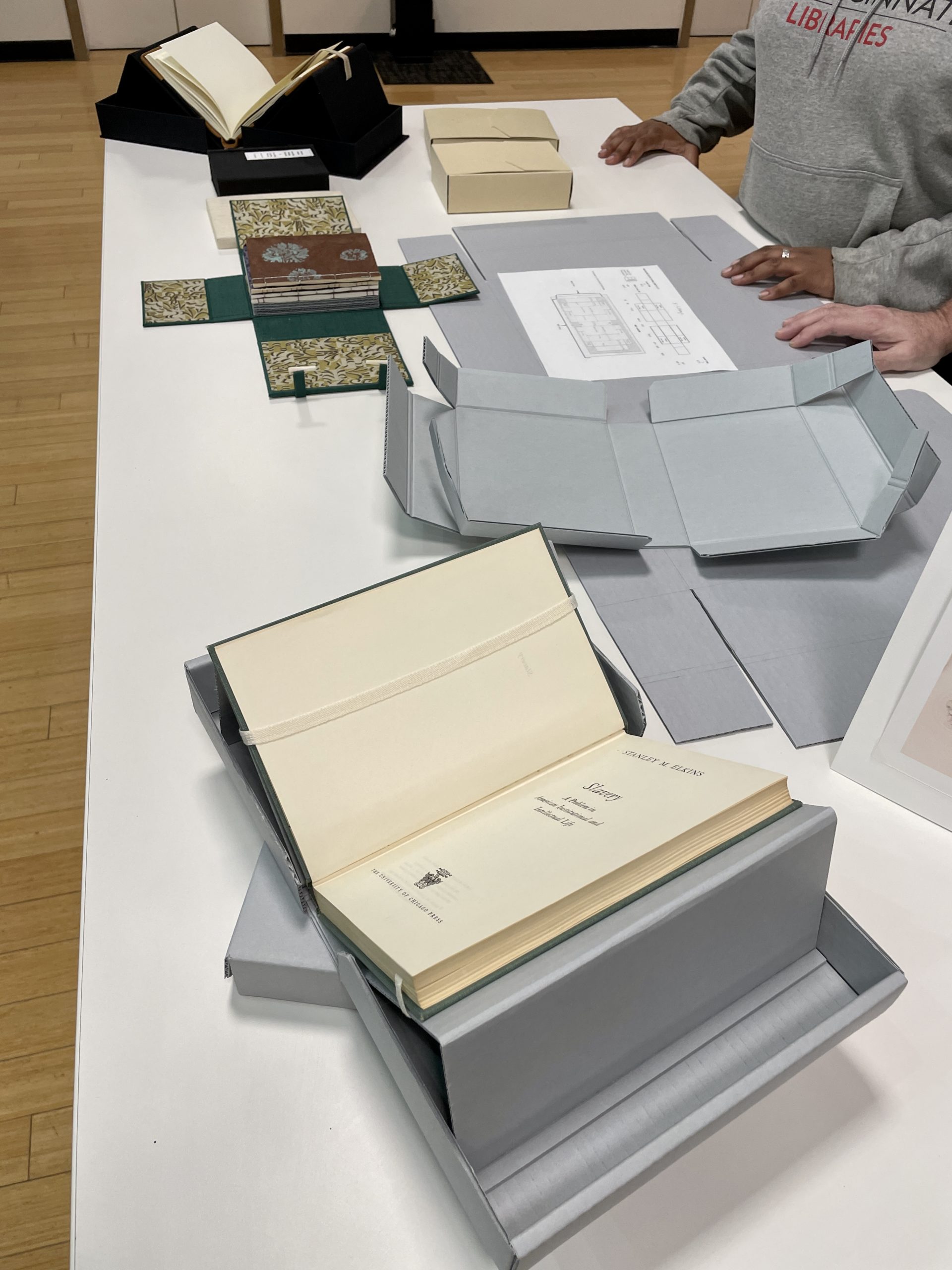 Table with various corrugated boxes highlighted, including one box that has a built in cradle.  