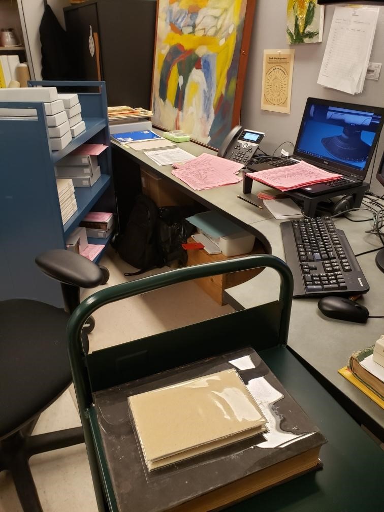 Office area with book carts full of return items.