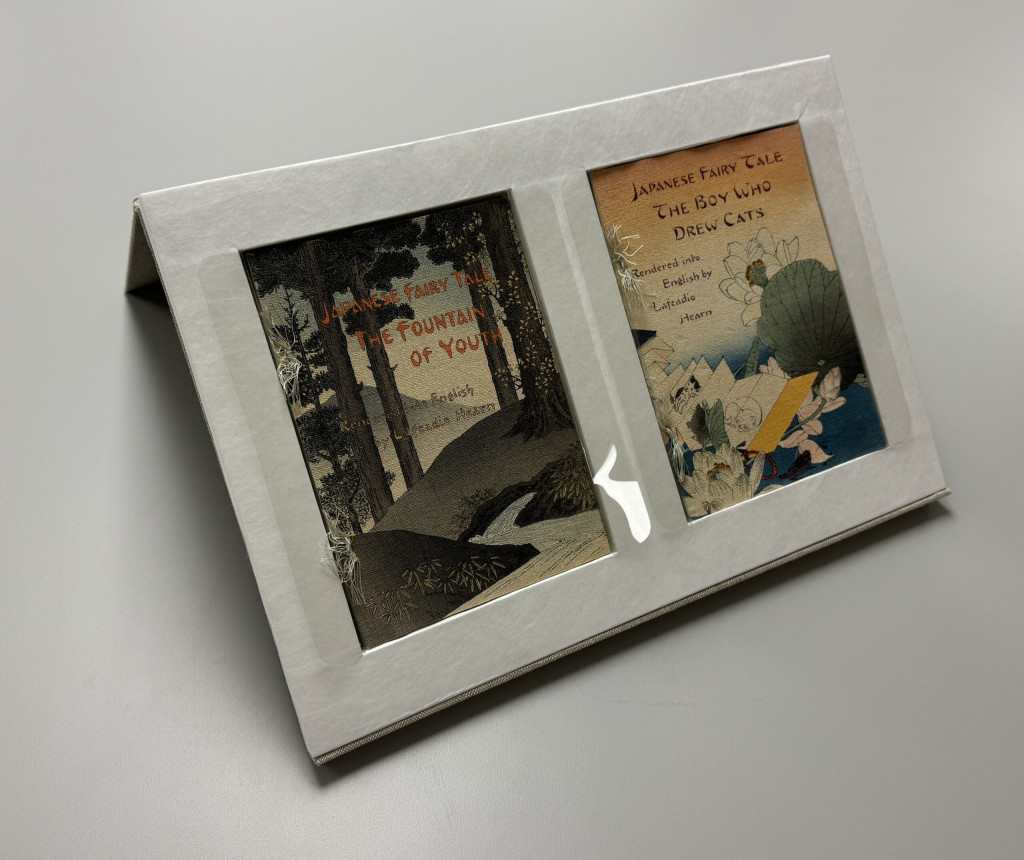 Display tray open, with four volumes in it, two volumes are visible and on display