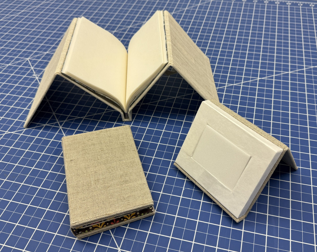 Three models pictured, two are collapsible cradles and one display stand with foam insert