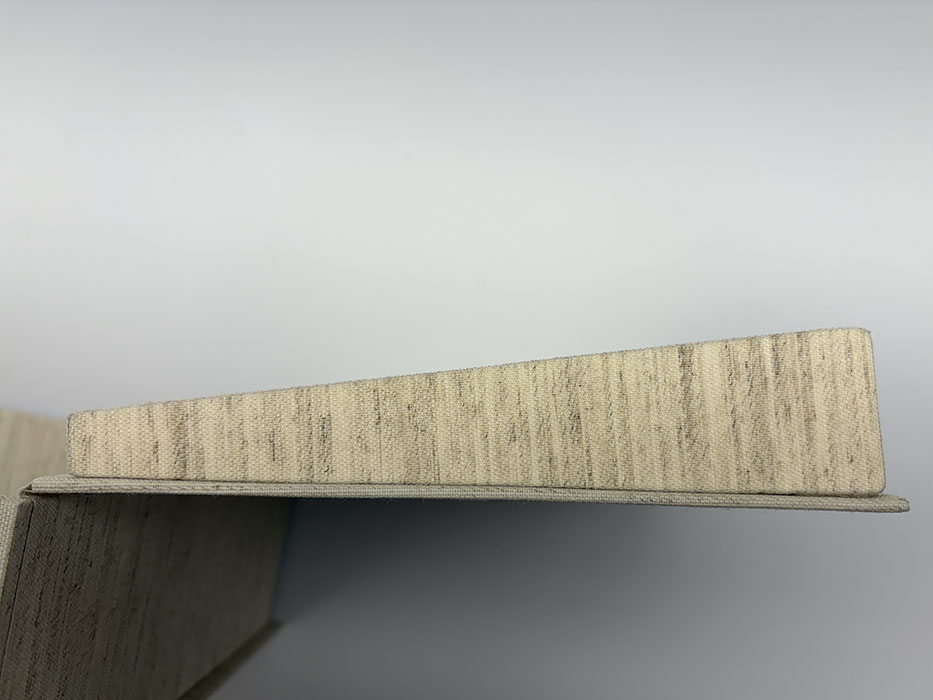 Image of wedge shape constructed of board and book cloth to support the deformed leather book.