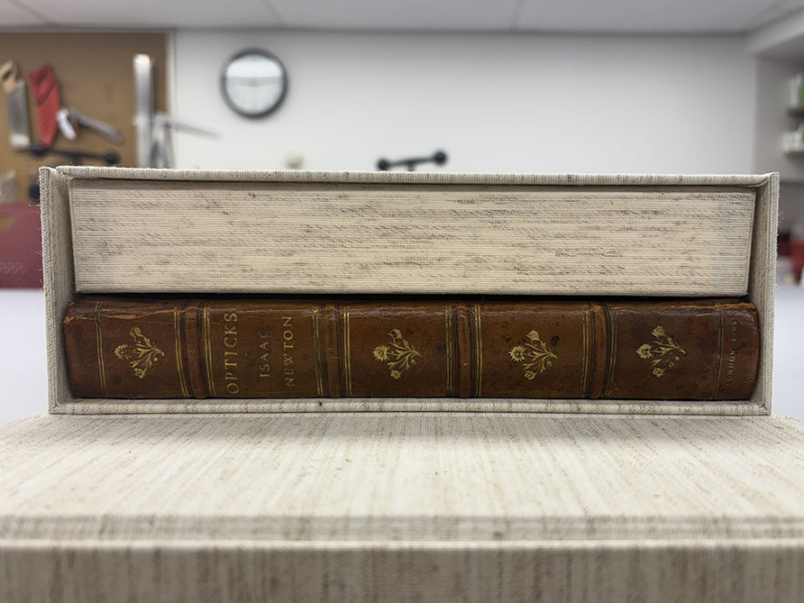 Cloth covered clamshell enclosure with leather book inside.