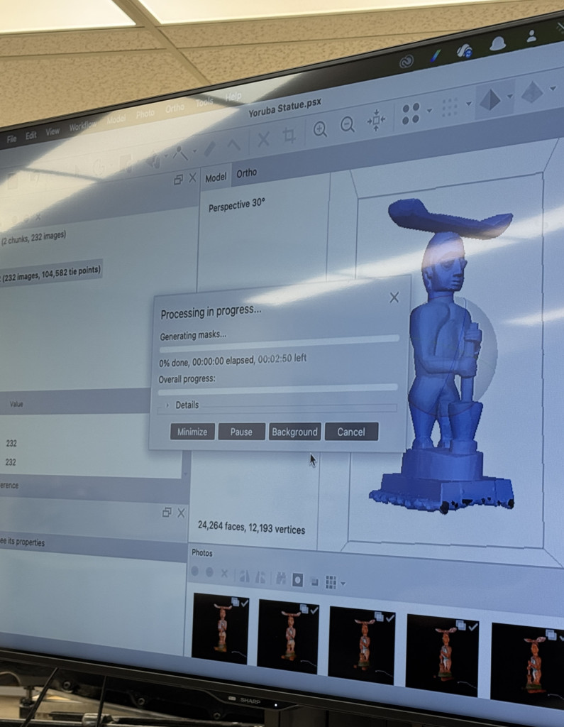 Screen with 3D imaging software showing a model of an African statue being processed.