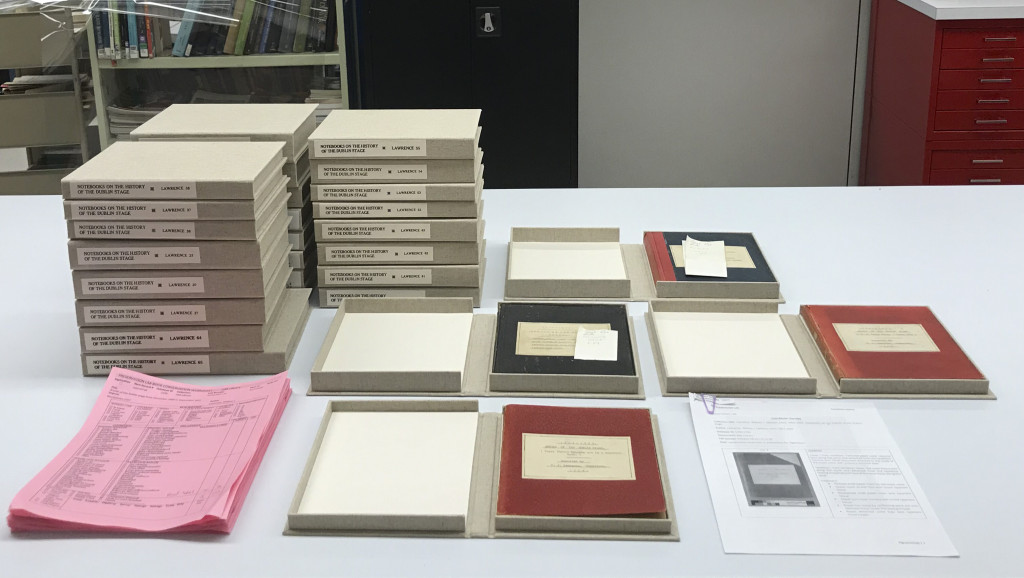 View of a stack of cloth clamshell enclosures, with several opened to show notebooks inside.