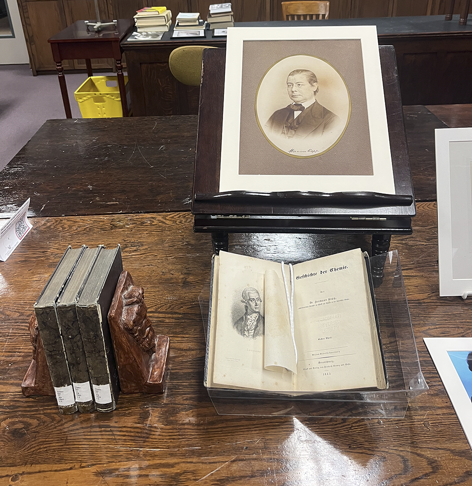 The surrogate display on a wooden table with a book open next to it and several other books displayed nearby.