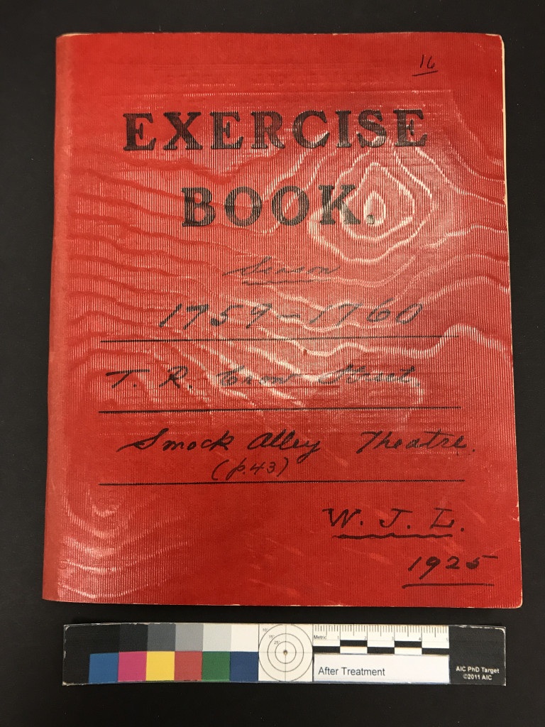 Overhead of a notebook with a shiny red cover.