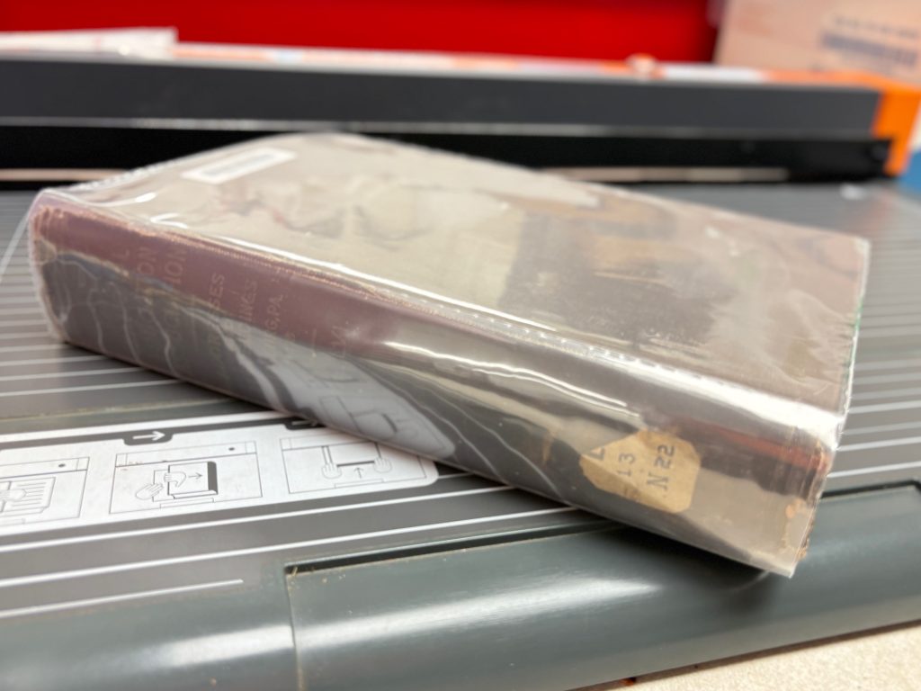 Book with completed jacket. Book is sitting on the CoLibri welder bed with view of spine.