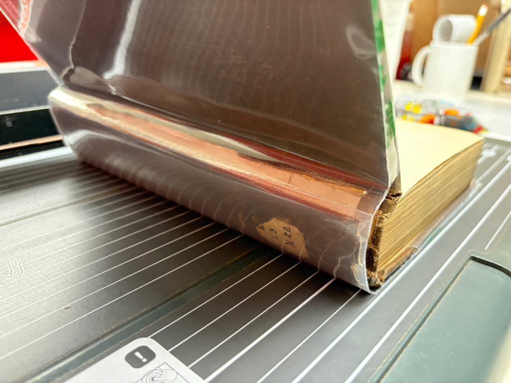 Book with front cover opened with view of the spine.