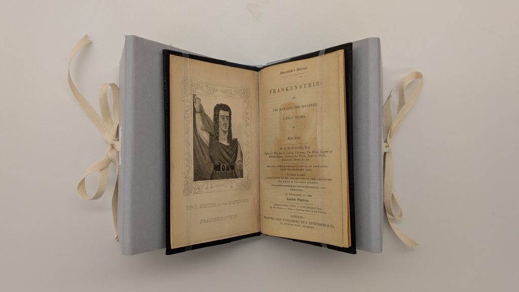 Aerial view of a small book strapped in a corrugated cradle.