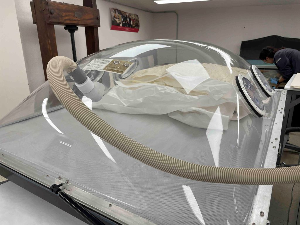 View of the humidification/suction table with parchment documents inside being humidification.