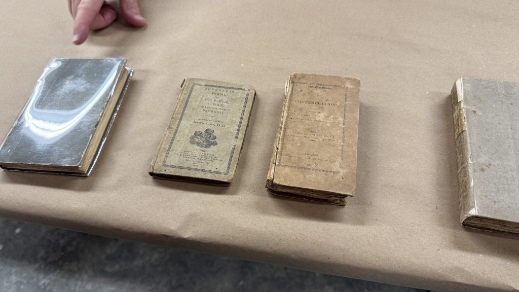 Four boarded binding examples, with the two in the center being examples of extra boarded bindings with printed covers.