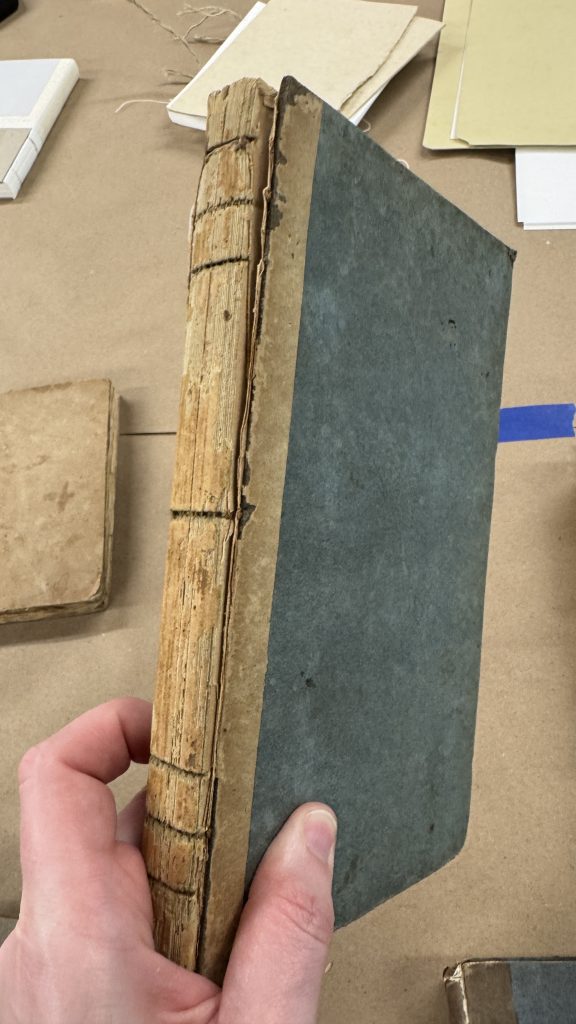 Quarter bound boarded binding with missing spine, which shows recessed sewing.