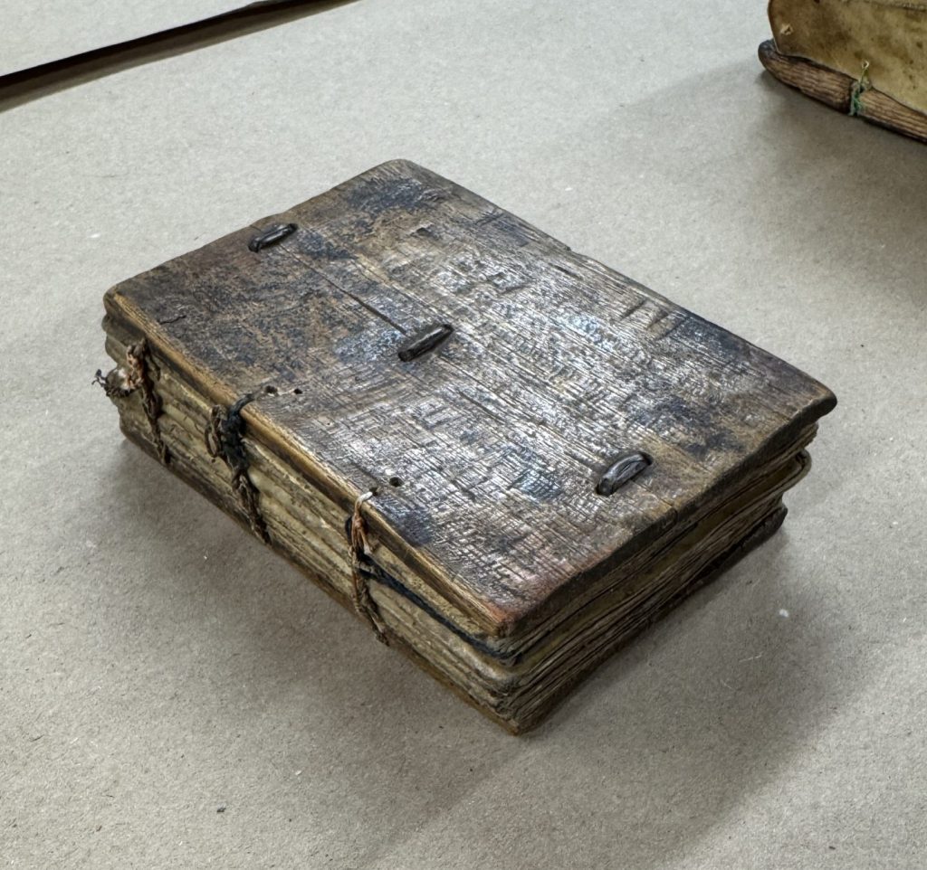 Small Ethiopian binding with wooden covers and exposed sewing on spine.