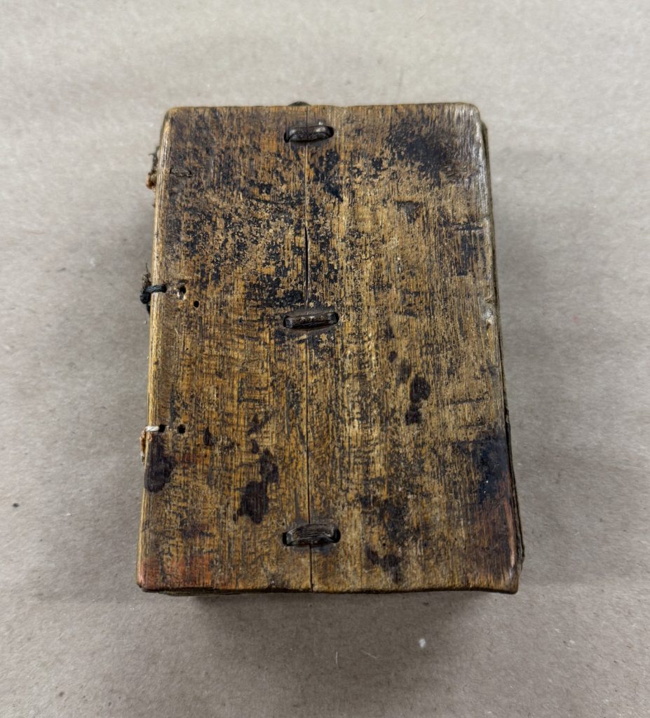 Small Ethiopian binding with wooden covers and a thread mend to repair the broken board.