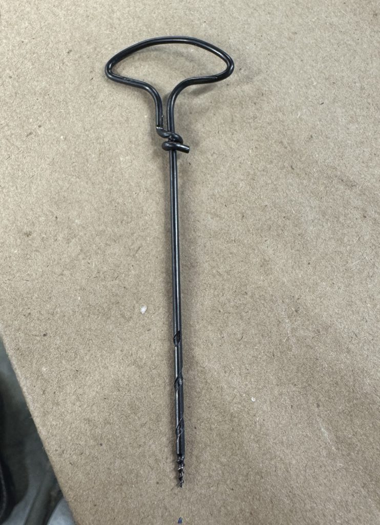 A gimlet tool which looks like a screw at the end.