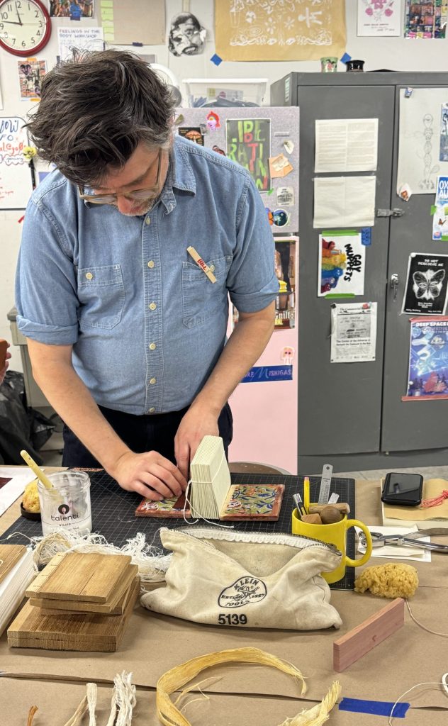 Instructor demoing how to attach the textile board lining and leather patch attachment before covering with leather.