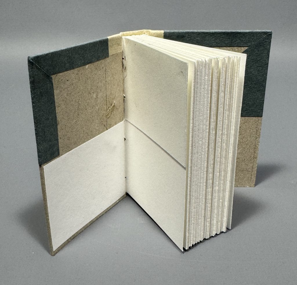 Smaller boarded binding cutaway model showing the inside of the front board, highlighting the laced on cord attachment.