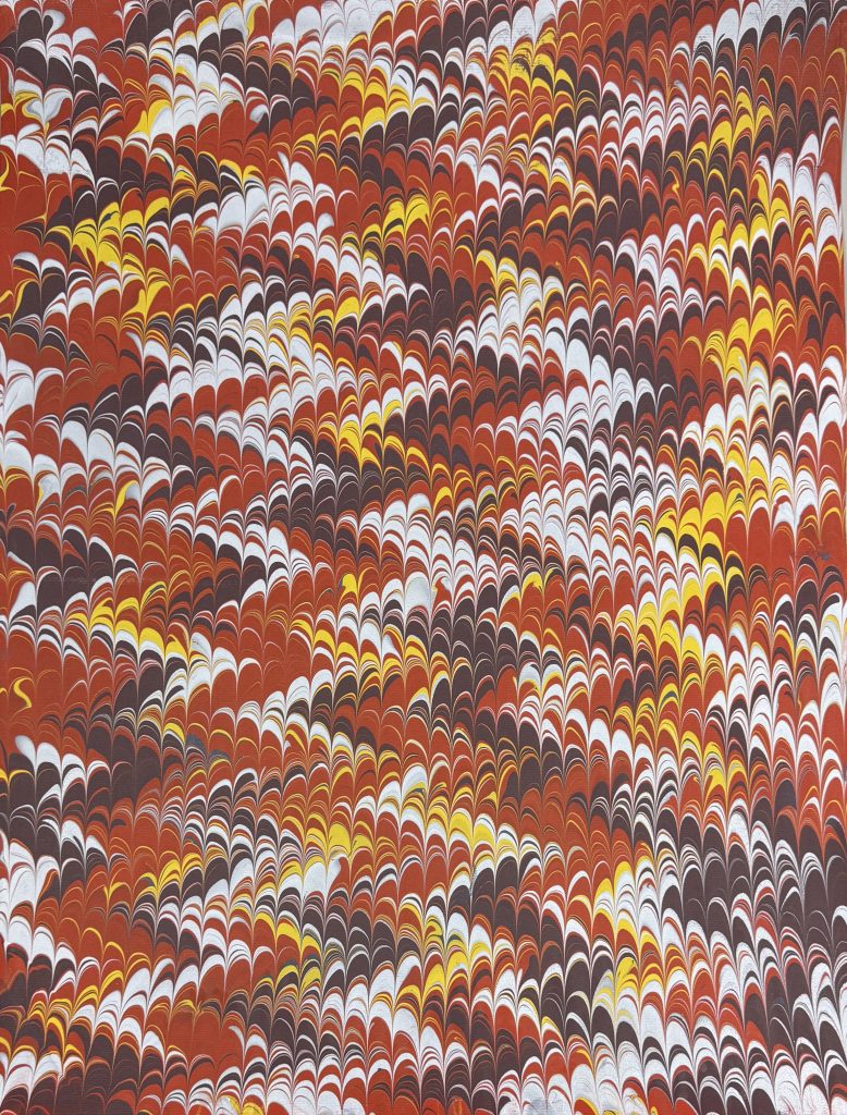 Nonpareil pattern in shades of red, mauve, yellow and white.