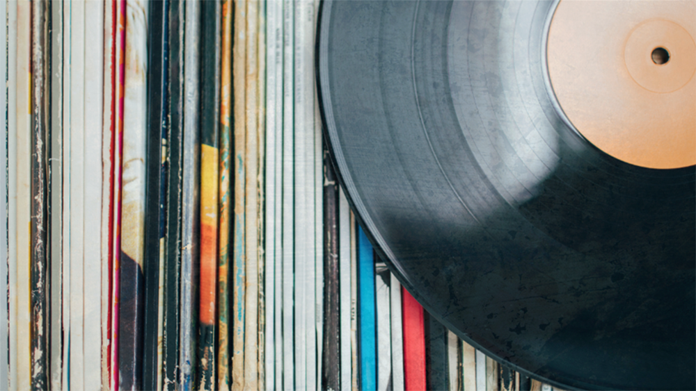 Record album in front of vertical sleeved albums.
