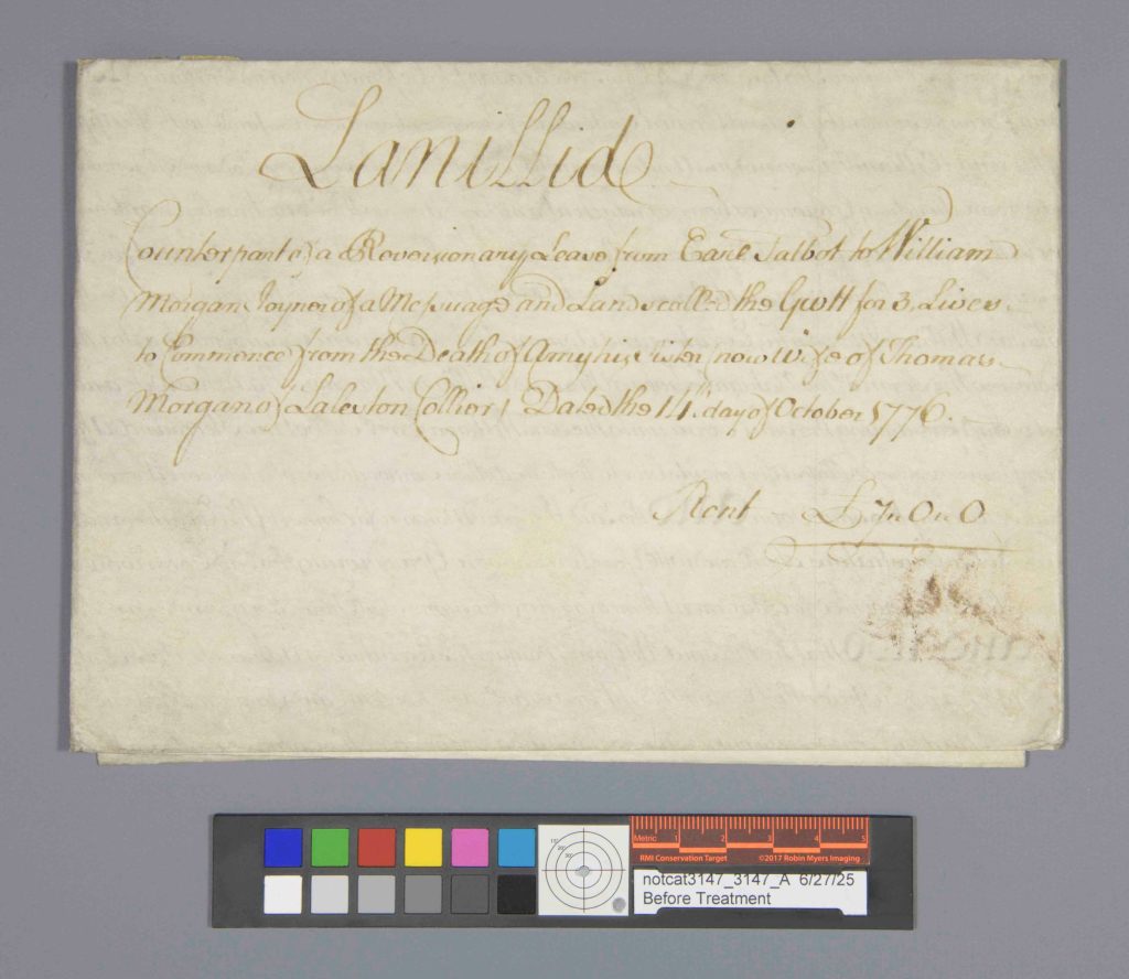 Folded parchment document with ink handwriting and a documentation color checker.