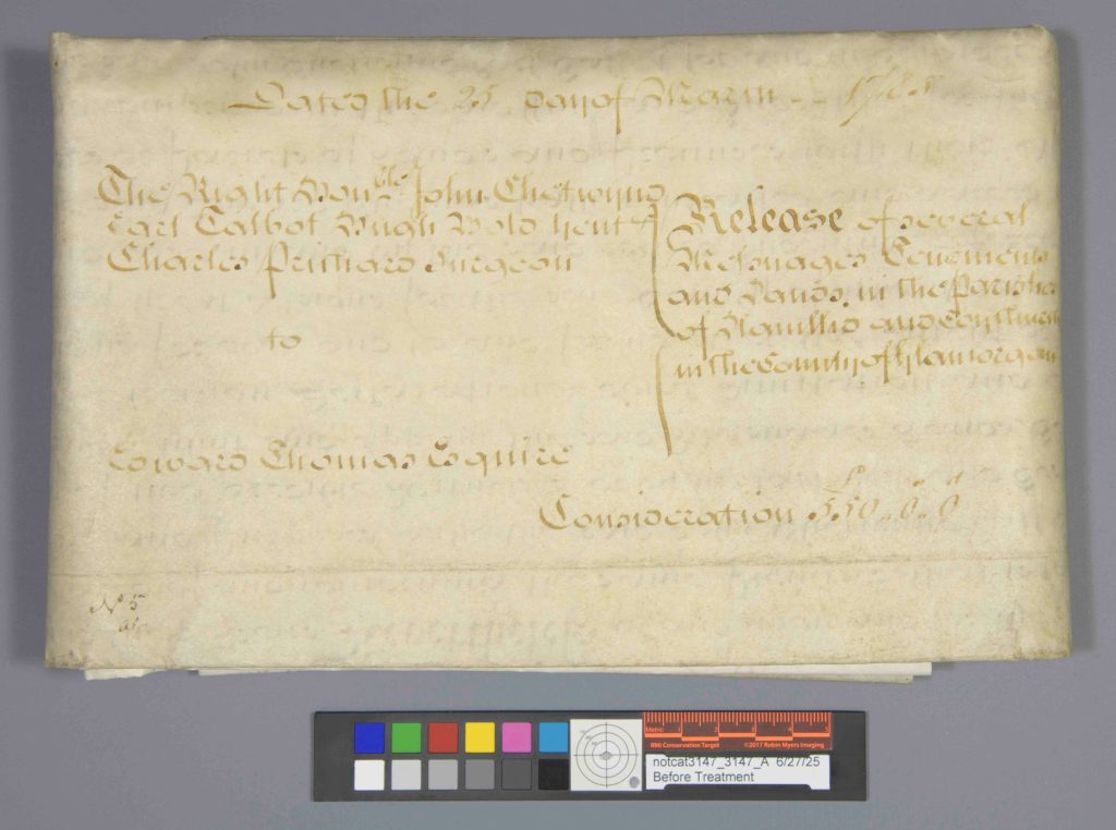 Folded parchment document with ink handwriting and a documentation color checker.