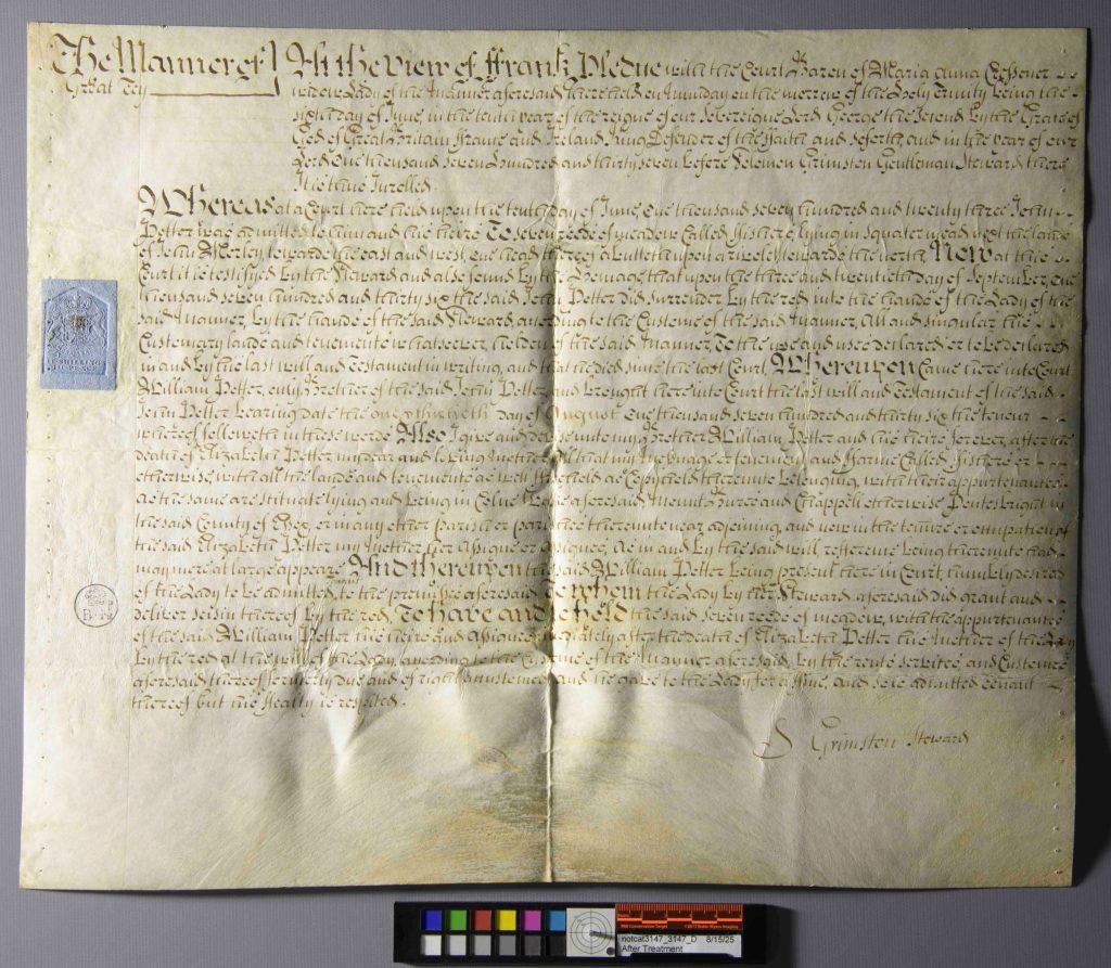 Overhead view of a parchment deed with light source casting shadows over the document to show the folds, which have reduced.