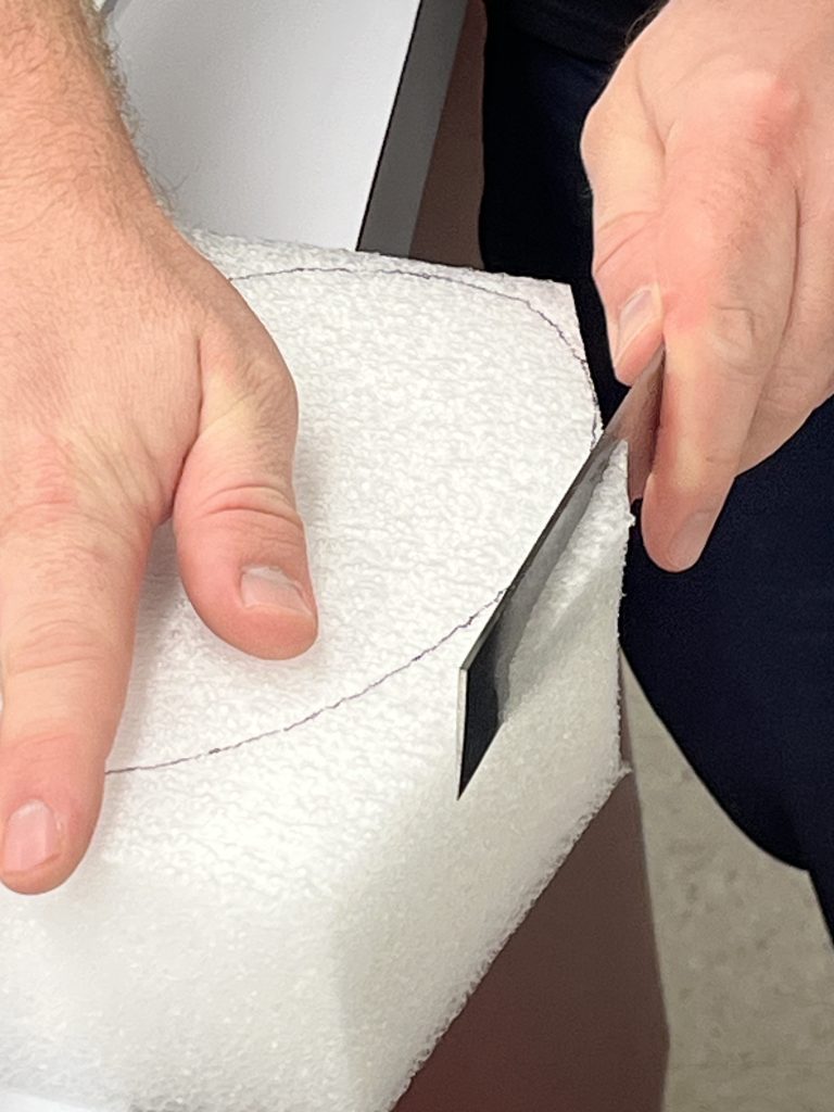 Cutting oval shape in ethafoam with an knife.