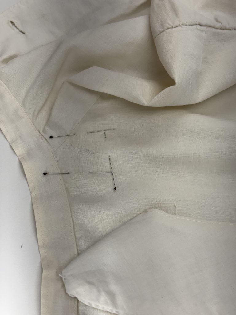 Close up of tear in nurse's uniform being repaired.