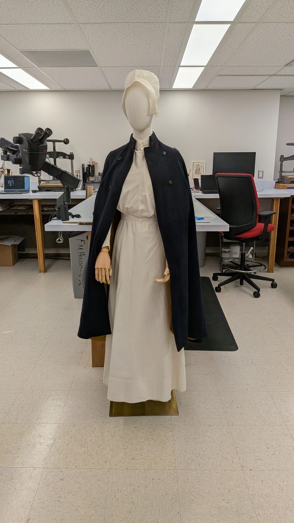 Mannequin dressed with a uniform and wool cape.