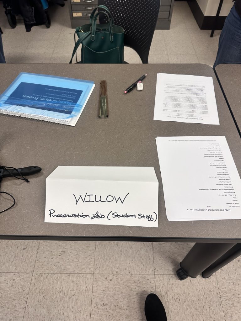 Willow table at the workshop with her binder and nametag.